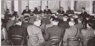 Asekätkentäjutun ensimmäinen istunto, jossa taustalla ovat tuomarit ja edessä syytetyt. Kuvan lähde on vanhahistoria.blogspot.com.