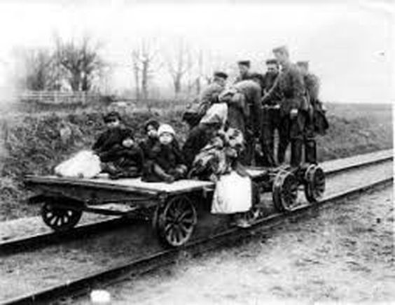 Saksalaiset sotilaat kuljettavat vuonna 1918 resiinalla lapsia ja äitiä, jotka ovat joutuneet lähtemään pakoon. Kuvan lähde on Kansan Arkisto.