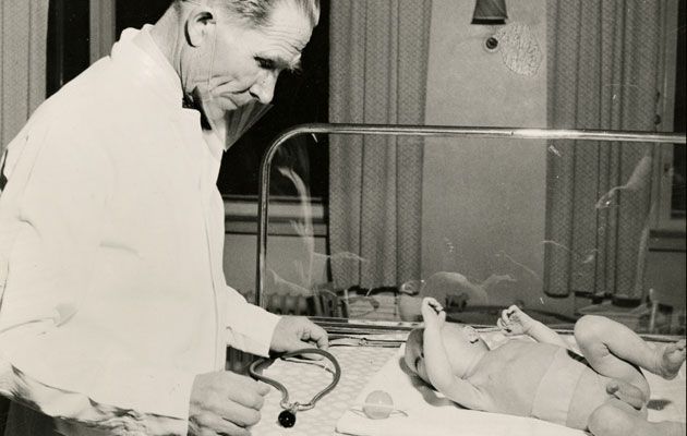 Arvo Ylppö tutkimassa vauvan vointia. Kuvan lähde on artikkeli ”Arvo Ylpön syntymästä 100 vuotta” Kotilieden ihmiset-ja-ilmiot” -nettisivuilta.