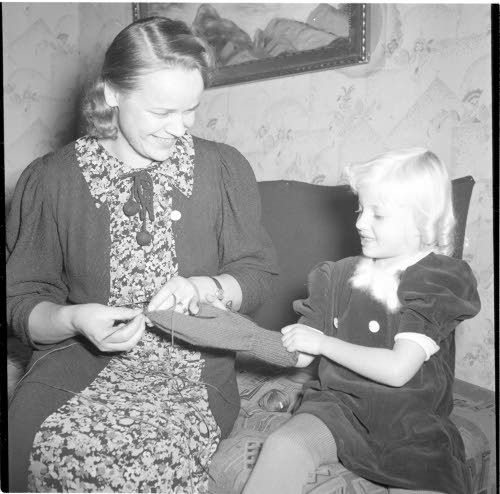Kuvassa äiti on neulomassa lapasta, jota tytär kokeilee 1.11.1939. Lähde on SA-kuvat.