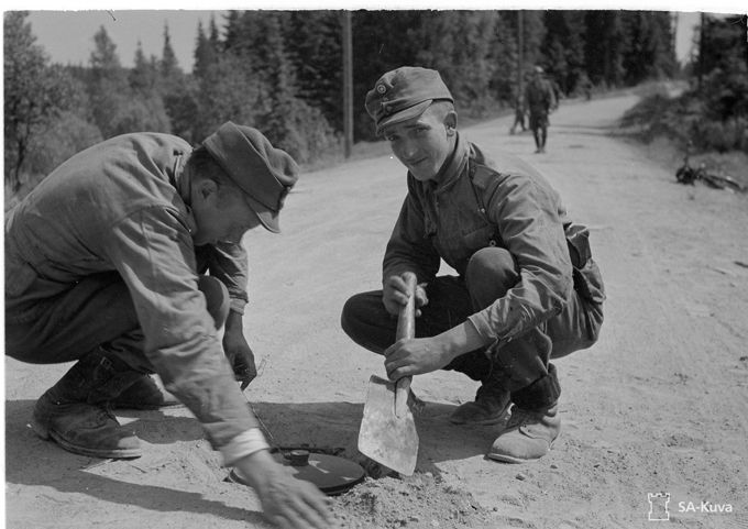 Jatkosodan vetäytymisvaiheessa pioneerit miinoittavat tietä. Kuvan lähde on SA-Kuva.