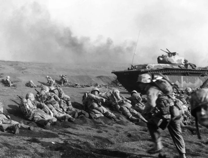 Kuva 2. Yhdysvaltain merijalkaväen toisen rykmentti odottaa siirtymistään sisämaahan Iwo Jimalla pian maihintulon jälkeen. Kuvan lähde on hmn.wiki.